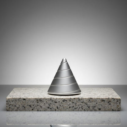 Grey Zenklar Vortex kinetic focus tool displayed on a minimal stone pedestal